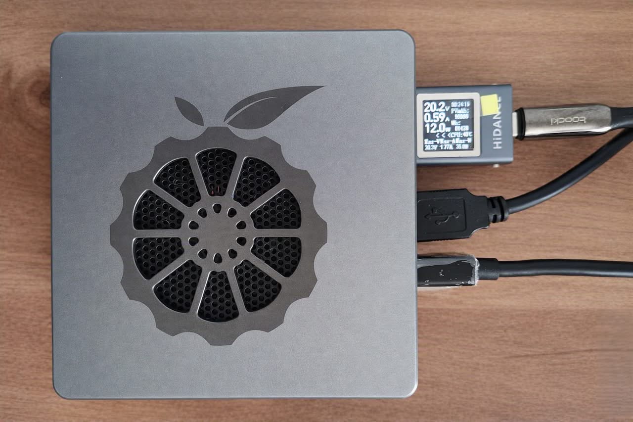 The Orange Pi 6 features a sleek design with a ventilation pattern and connected cables for power and data transfer.